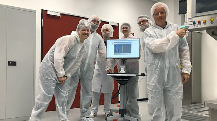 Ferring pharmaceutical manufacturing team posing for the photo next to their EBR system.  